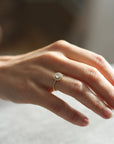 Model wearing the Halo Aura Solitaire Engagement Ring in yellow gold by Fluid Jewellery 3