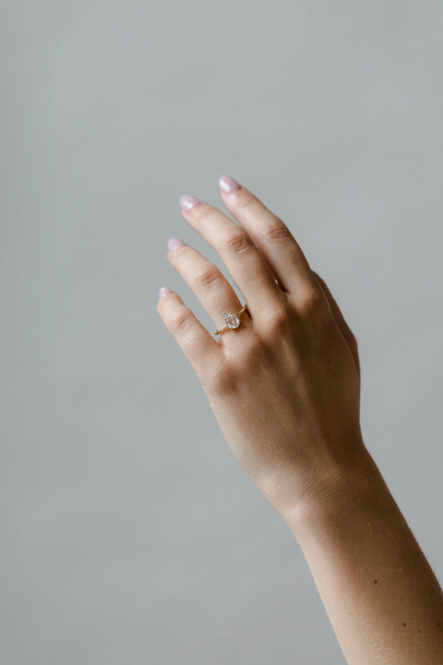 Model wearing the Avery Solitaire Engagement Ring in yellow gold by Fluid Jewellery