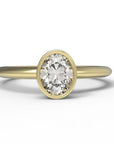 Close up of the Bezel Isla Solitaire Engagement Ring in yellow gold by Fluid Jewellery