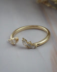 Side close-up of the Aster open guard wedding band showing marquise and round diamonds in a flower inspired gold setting.