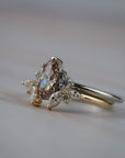Close-up of an Aster diamond wedding band with marquis and round diamonds with an engagement ring