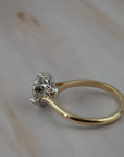 Close-up of the side profile of the Cala solitaire showing the two-tone platinum setting and gold band with antique filigree inspired details.