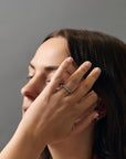 Lifestyle close-up of women's hands wearing the Constellation diamond gold wedding band.