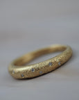 Luna textured Fairmined yellow gold wedding band featuring delicate Canadian diamonds set in a handcrafted design.