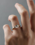 Close-up of a woman wearing the Magnolia half bezel solitaire with an elongated Old European cushion cut diamond and hand engraved magnolia flowers.