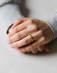 Close up of model hand wearing the mens Hammer wedding band in yellow gold