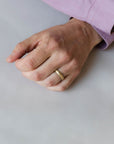 Close up of models hand wearing the mens Milgrain wedding band in gold 2