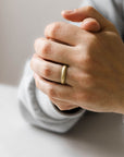 Close up of models hand wearing the mens Milgrain wedding band in gold