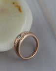 Close-up of the hand engraved floral details on the side of the Mrs. Erykah Fairmined gold engagement ring.
