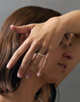 Stylized close-up of women wearing an organic textured leaf wedding band featuring Canadian diamonds