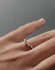 Close-up of a woman's hand wearing the Snowflake curved diamond wedding band, featuring delicate diamonds in a snowflake inspired design.
