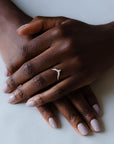 Close up of model hand wearing the Chevron Clara womens wedding band by Fluid Jewellery in yellow gold