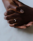 Close up of model hand wearing the Chevron Clara womens wedding band by Fluid Jewellery in yellow gold