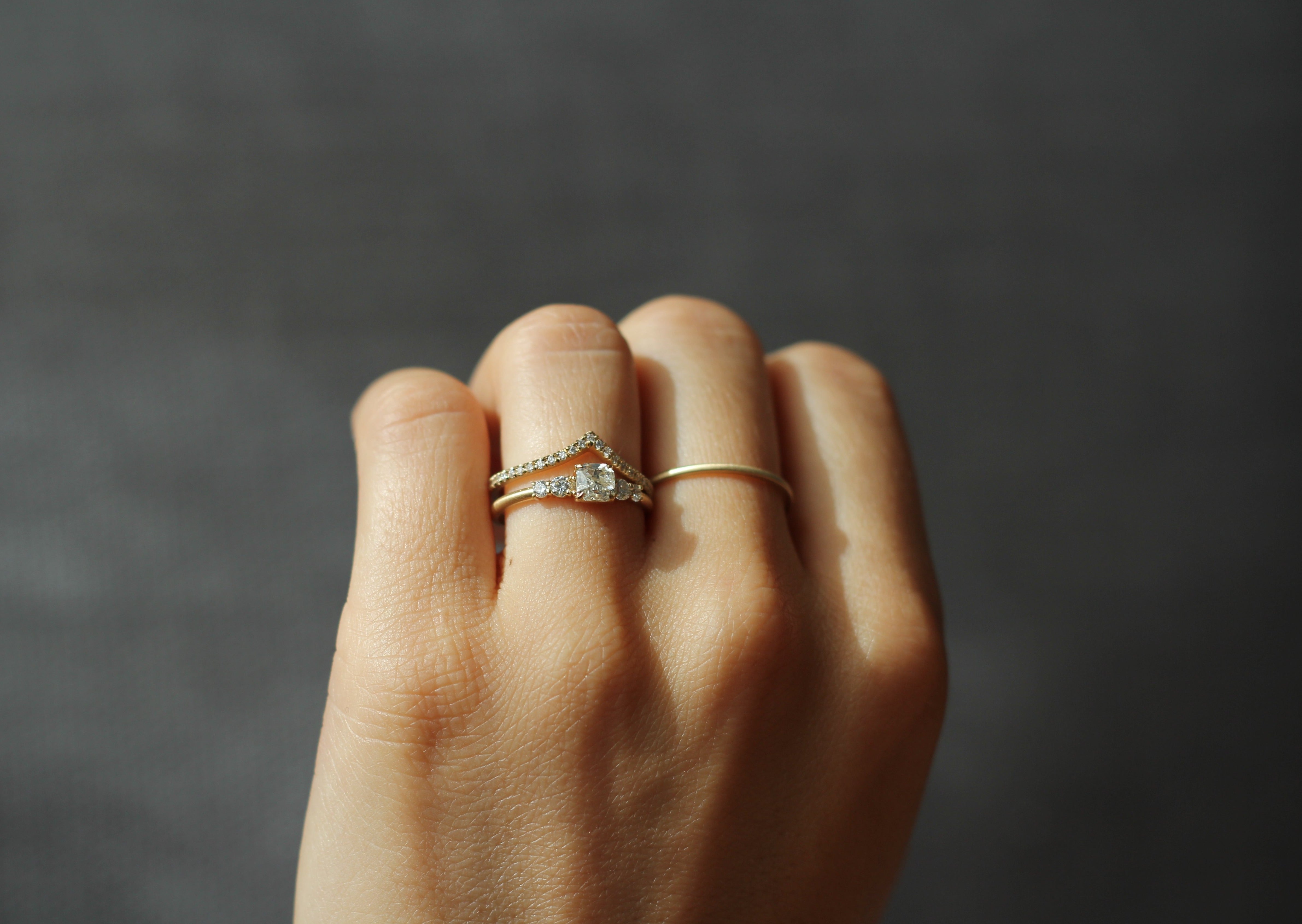 Close up of model hand wearing the Chevron Mia womens wedding band by Fluid Jewellery in yellow gold 3