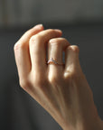 Close up of model hand wearing the Chevron Penelope womens wedding band by Fluid Jewellery in gold