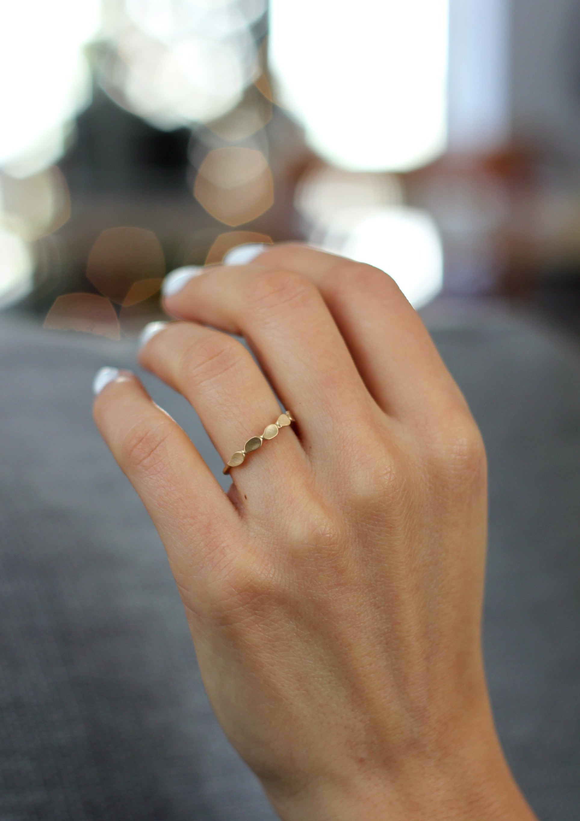 Close up of model hand wearing the Lotus womens wedding band by Fluid Jewellery in gold 2