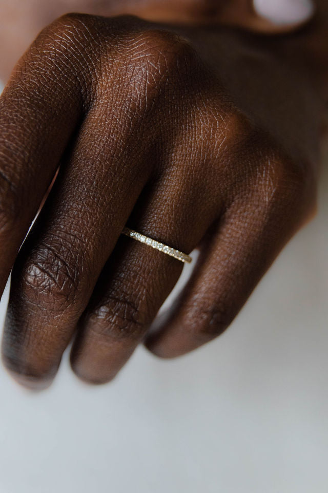 Close up of model hand wearing the classic Eternity womens wedding band by Fluid Jewellery in yellow gold 2