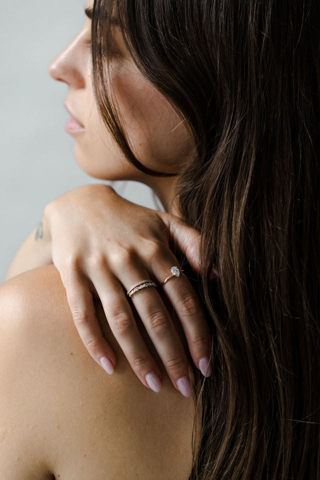 Close up of model hand wearing the cluster Marissa womens wedding band by Fluid Jewellery in yellow gold 3