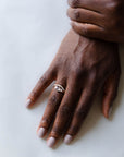 Close up of model hand wearing the curved Caia womens wedding band by Fluid Jewellery in yellow gold 4