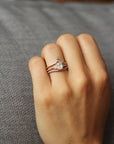 Close up of model hand wearing the curved flow womens wedding band by Fluid Jewellery in rose gold