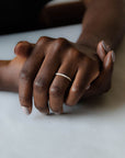 Close up of model hand wearing the classic Eternity womens wedding band by Fluid Jewellery in yellow gold