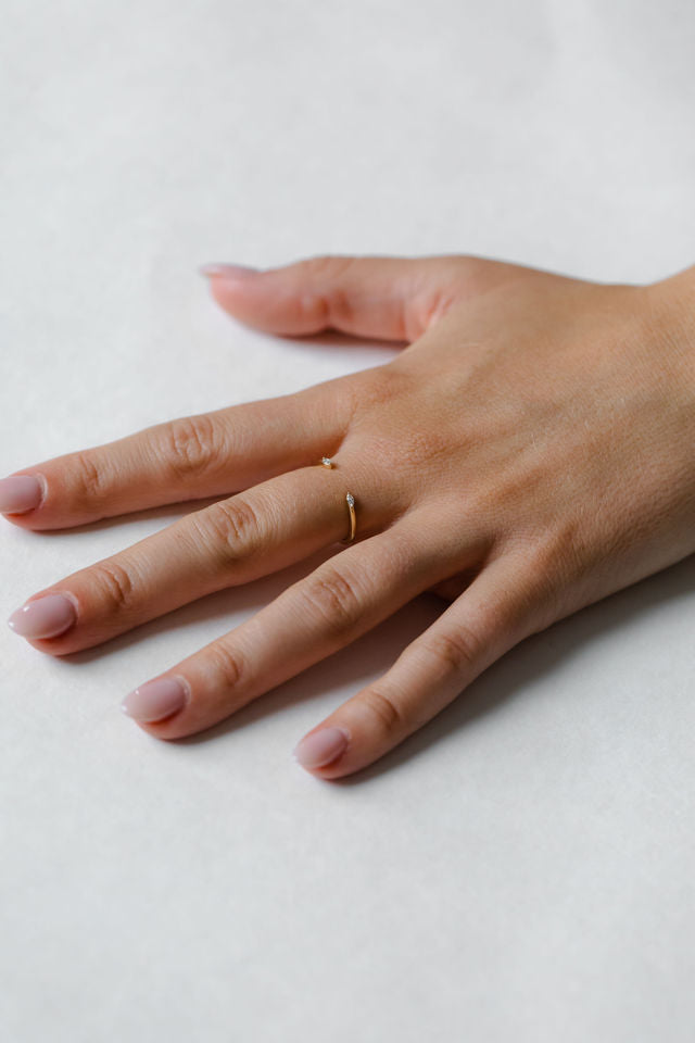 Close up of model hand wearing the open Mara womens wedding band by Fluid Jewellery in yellow gold 2