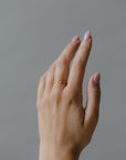 Close up of model hand wearing the open Mara womens wedding band by Fluid Jewellery in yellow gold