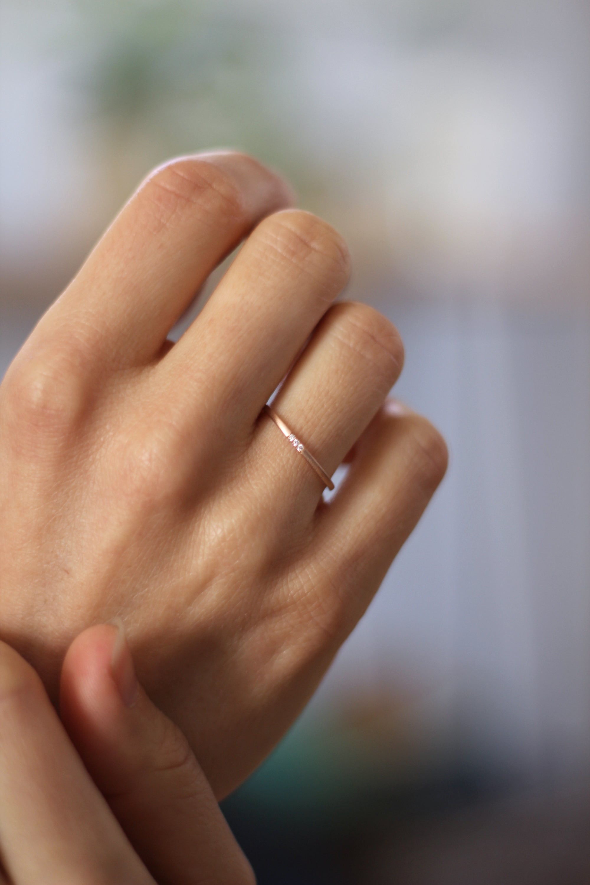 Close up of model hand wearing the Pave Jane womens wedding band by Fluid Jewellery in rose gold