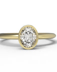 Close up of the Bezel Isla Solitaire Engagement Ring in yellow gold by Fluid Jewellery