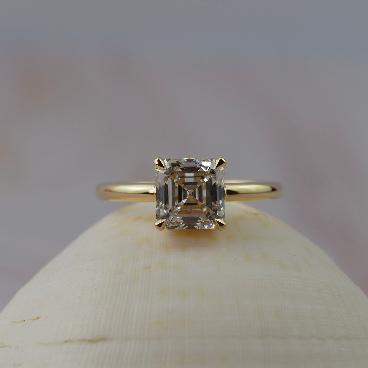 Low profile Asscher cut diamond claw solitaire engagment ring featuring delicate floral scroll along the side of the setting. 