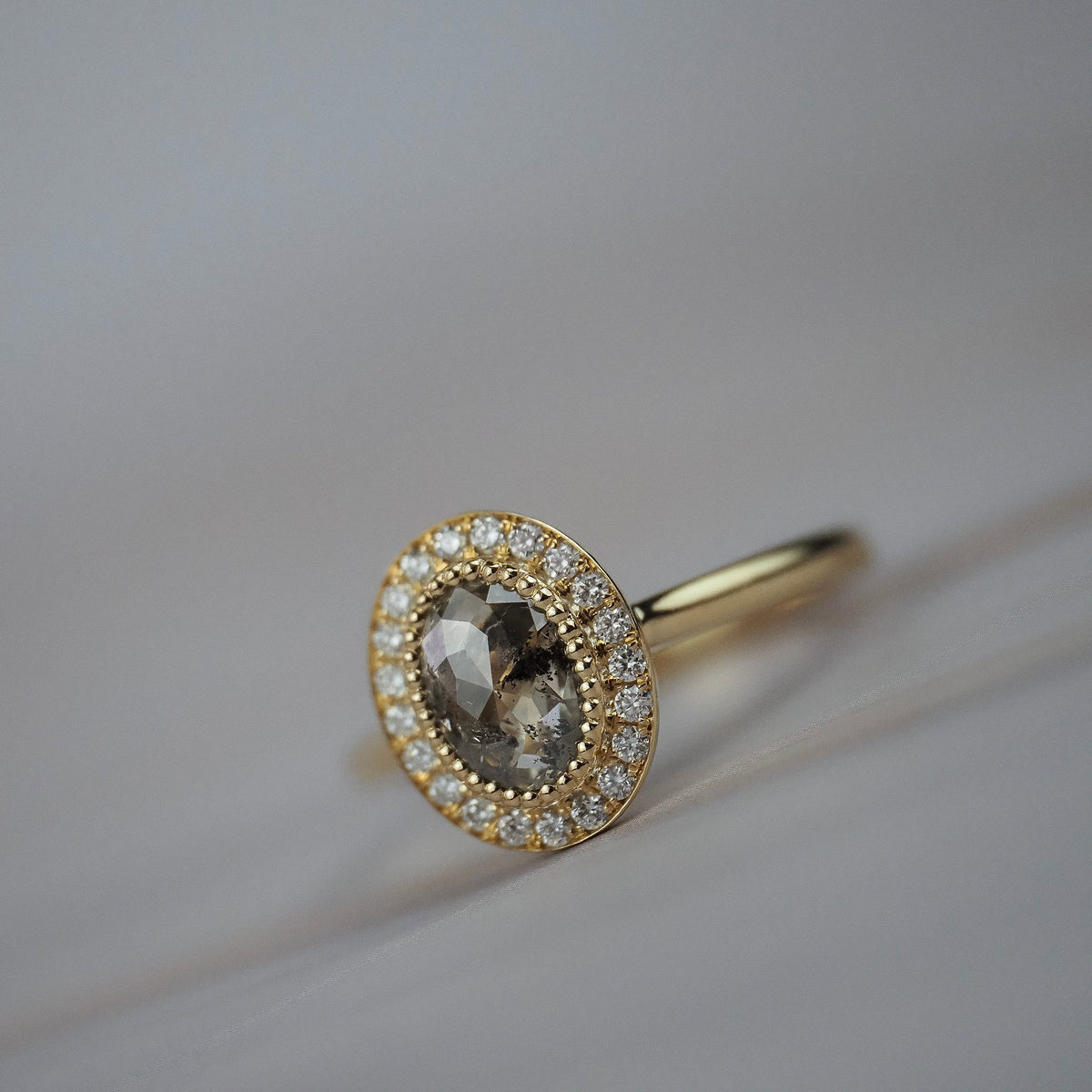 Aura halo solitaire engagement ring featuring a champagne-toned Australian salt and pepper rose-cut diamond surrounded by Canadian diamonds