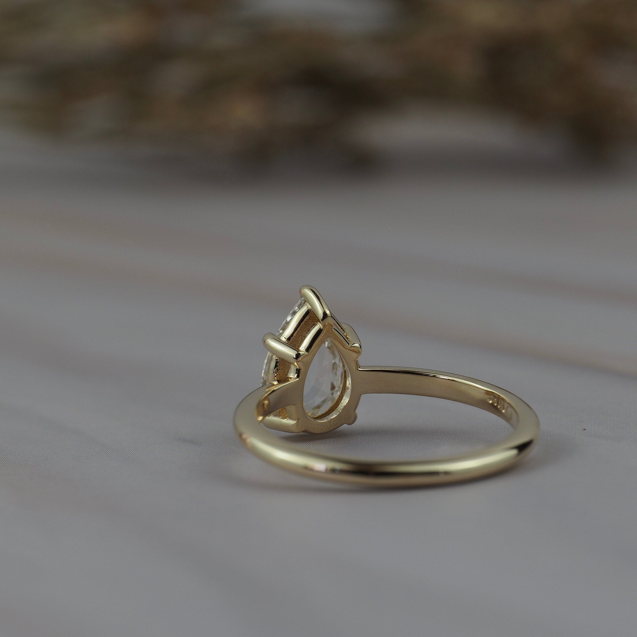Back view of the Avery pear shaped rose cut diamond solitaire engagement ring showing the gold setting.
