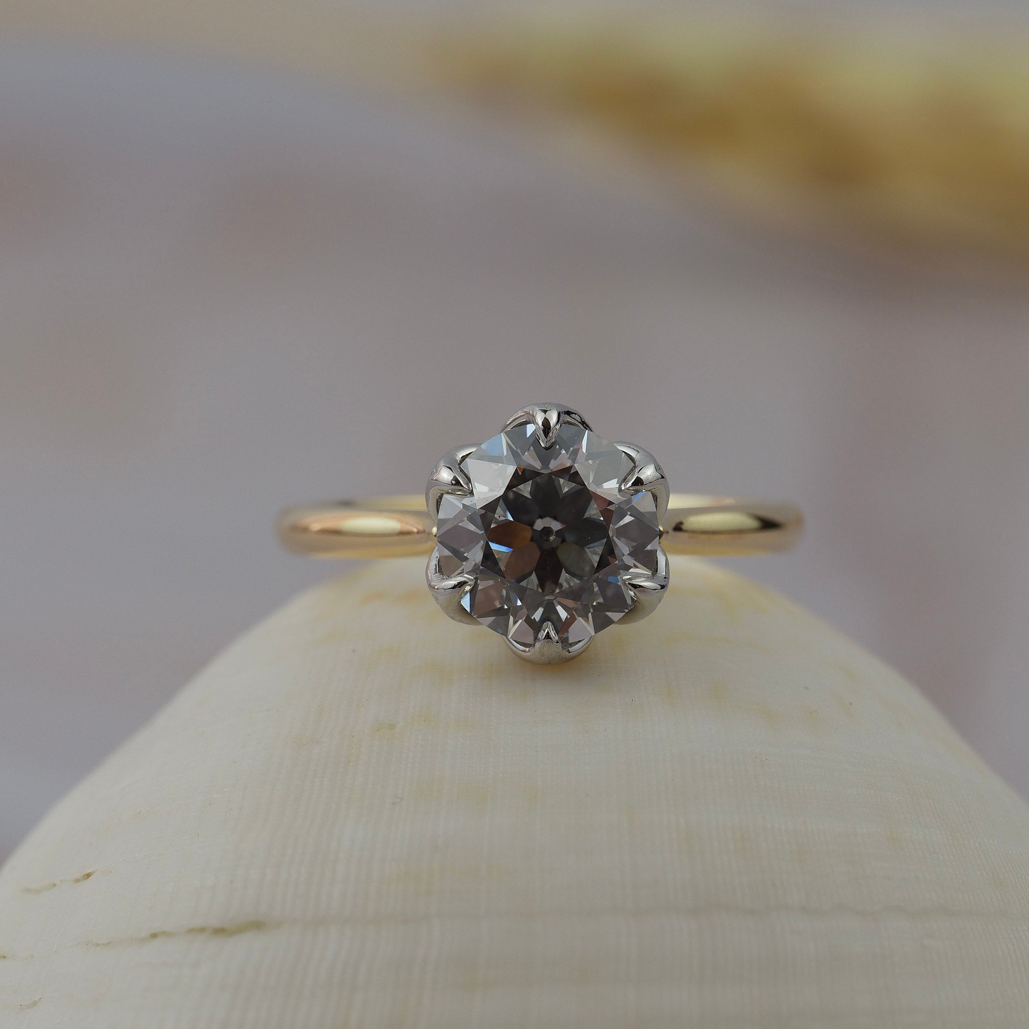 Cala solitaire engagement ring a tulip style antique floral filigree-inspired platinum and gold setting featuring a round Old European diamond.
