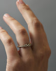 Close-up of the Constellation diamond gold wedding band worn on a woman's finger, featuring delicate scattered diamonds.