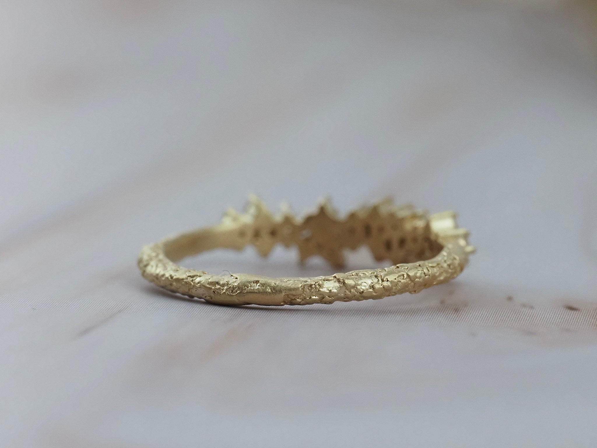 Back view of the Constellation diamond gold wedding band showing it's textured gold finish.