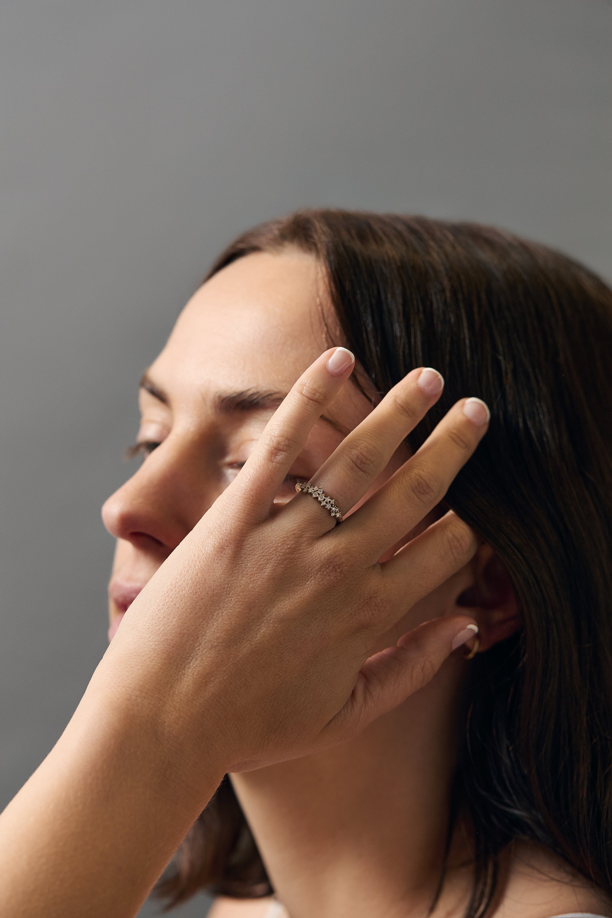 Lifestyle close-up of women's hands wearing the Constellation diamond gold wedding band.