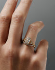 Cora split-shank milgrain emerald cut diamond solitaire paired with the Pernelle curved French pave diamond wedding band on a woman's finger.