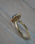 Close-up side and back view of the Elanor salt and pepper oval diamond solitaire showing its Art Deco women's basket setting, and double milgrained beaded edge.