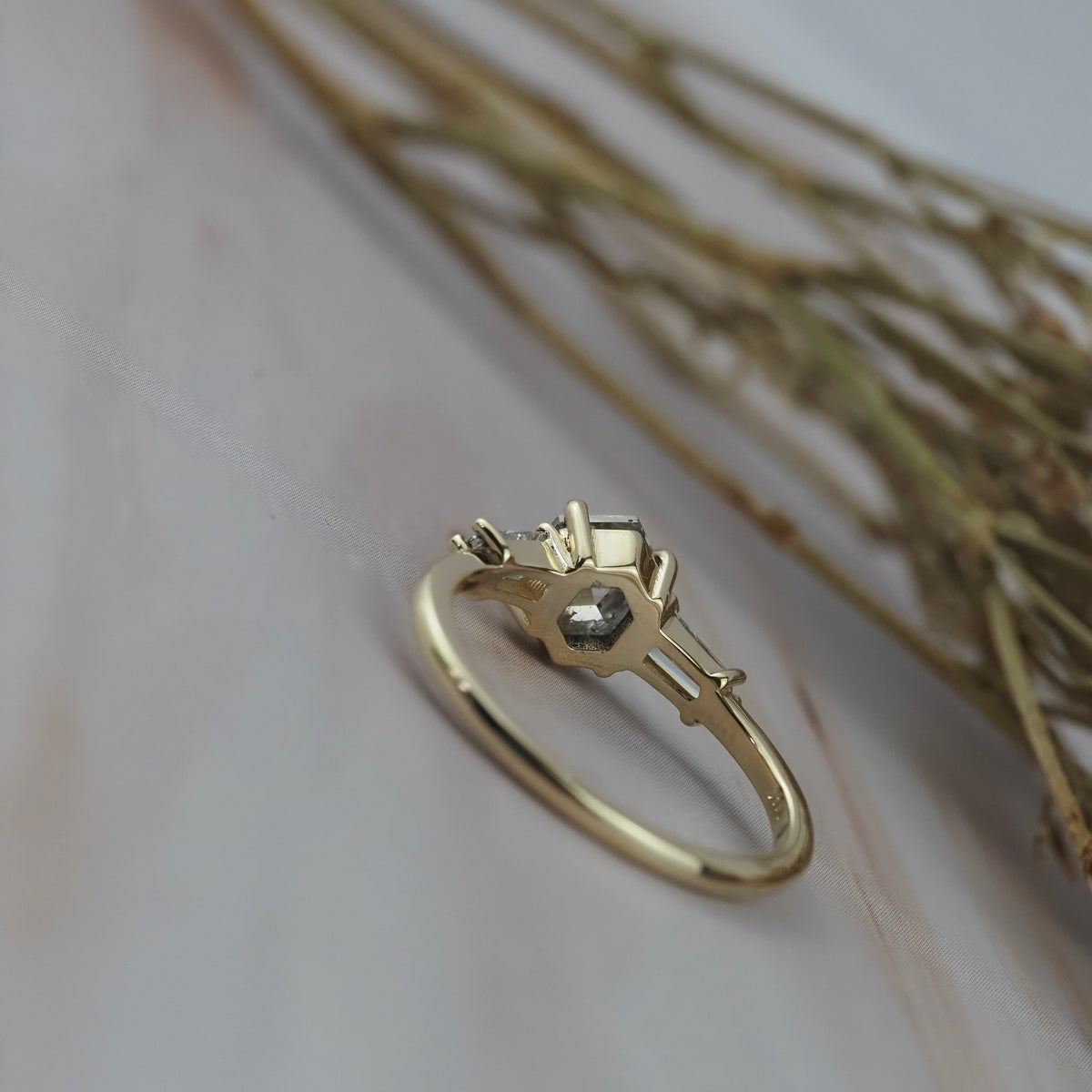 Back profile of the Esme hexagon-shaped salt and pepper diamond engagement ring showing the gold setting and tapered baguette diamonds. 