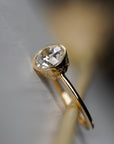 Flora gold milgrain bezel solitaire featuring an Old European cut diamond with floral engravings along the sides.