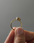 Close-up side profile of the Flora gold solitaire showing the milgrain bezel and hand-engraved floral details.