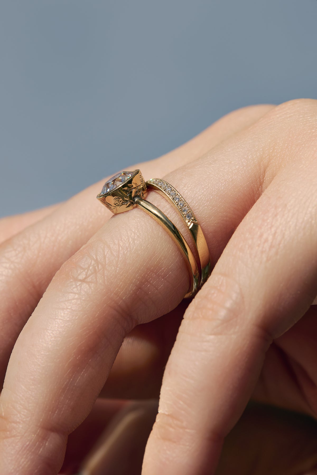Close-up side profile of the Flora Old European cut diamond solitaire paired with a milgrain diamond wedding band, showing the floral engravings.