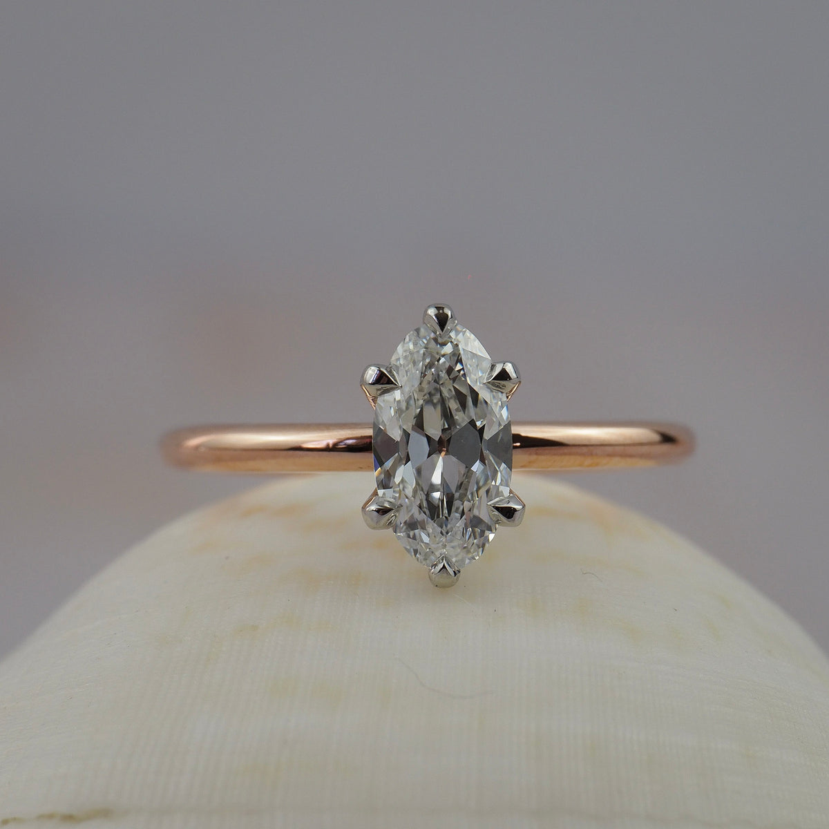 Lena six-claw solitaire engagement ring featuring a moral shaped antique cut Old European diamond in two-tone platinum and rose gold setting.
