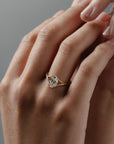 Love Knot split shank diamond solitaire engagement ring featuring a hidden halo and intertwined gold setting on hand.