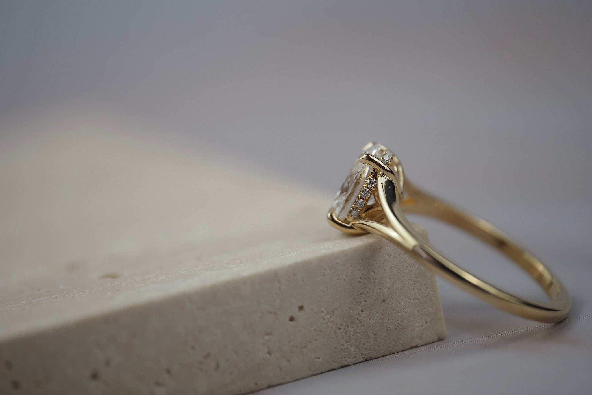 Close-up side view of the Love Knot diamond solitaire engagement ring showing the hidden halo and split shank setting.