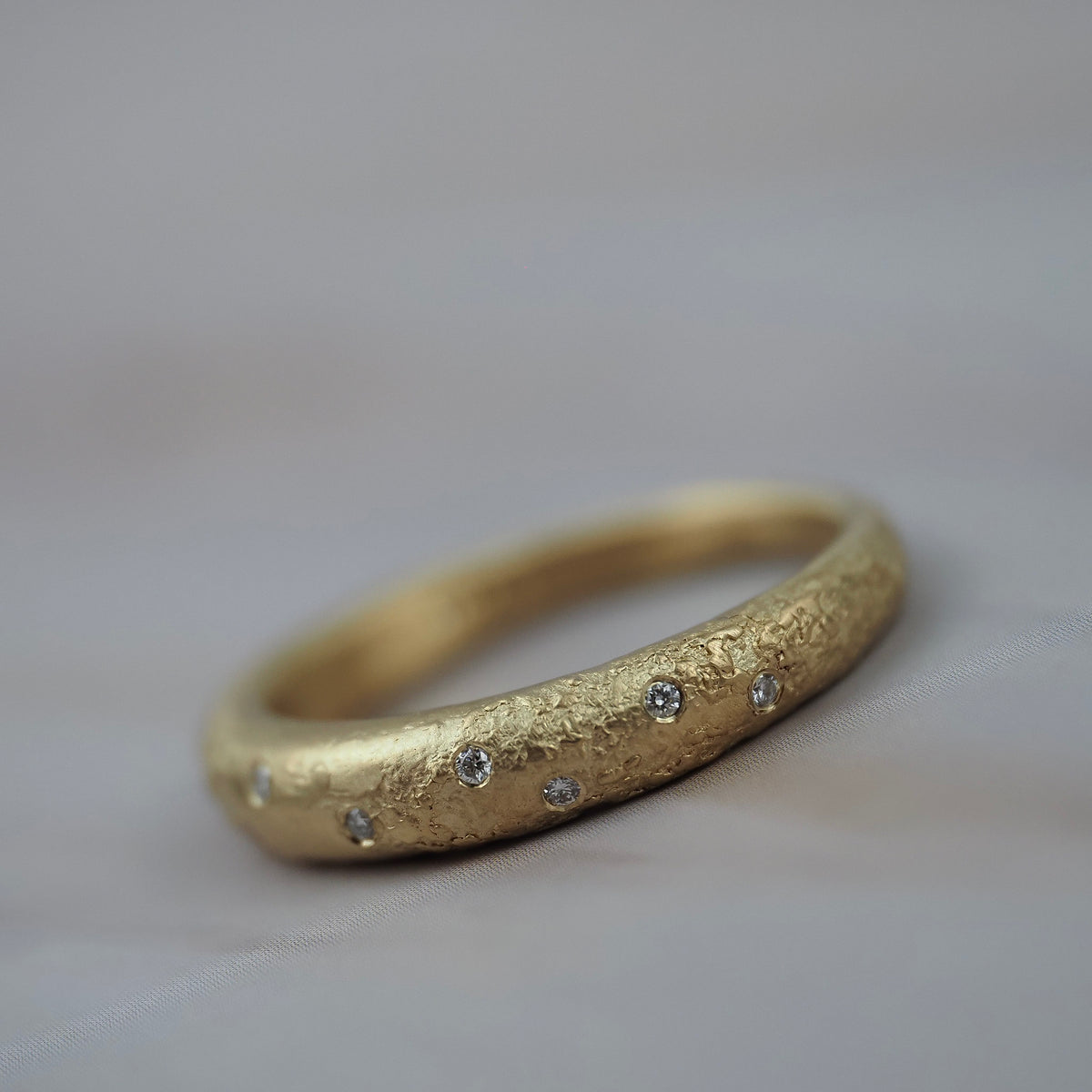 Luna textured Fairmined yellow gold wedding band featuring delicate Canadian diamonds set in a handcrafted design.