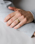 Close up of model hand wearing the mens Arena wedding band in yellow gold