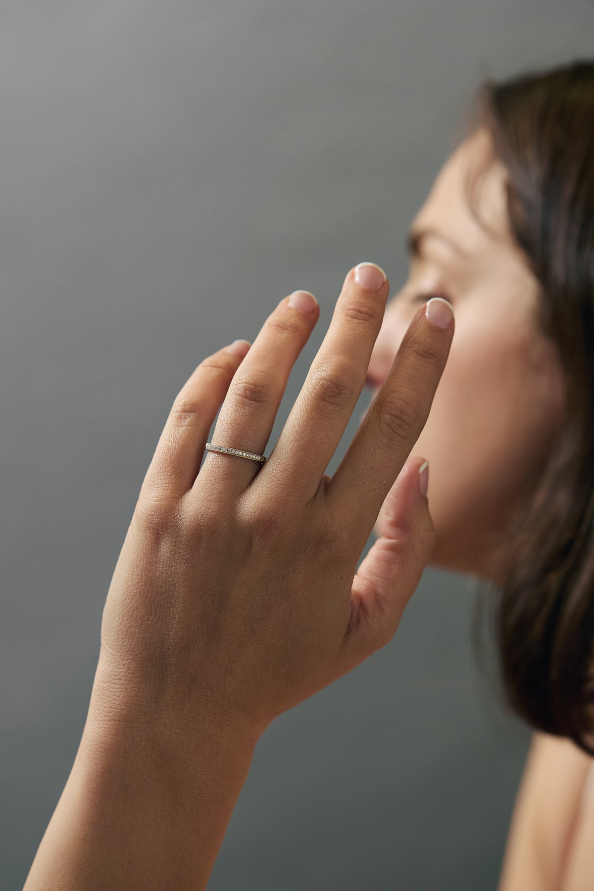 Lifestyle close-up of a model wearing a handcrafted migraine Fairmined gold wedding band with Canadian diamonds.
