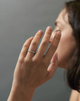 Lifestyle close-up of a model wearing a handcrafted migraine Fairmined gold wedding band with Canadian diamonds.