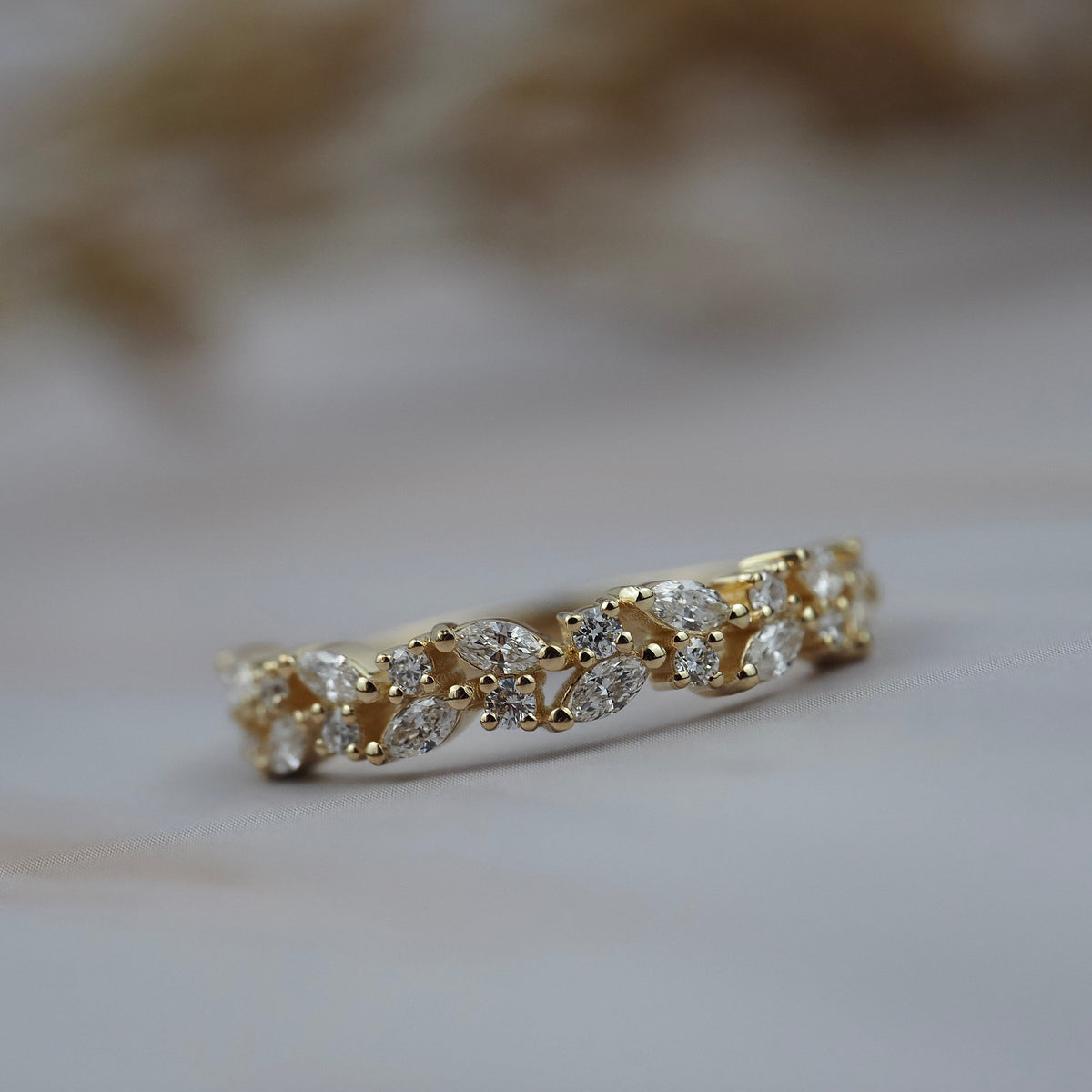 Navette diamond cluster wedding band in gold featuring round and marquise diamonds in a floral inspired design.